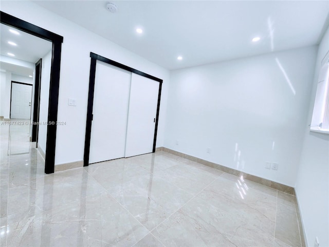 unfurnished bedroom featuring a closet and light tile flooring