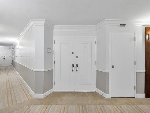 carpeted foyer entrance featuring ornamental molding