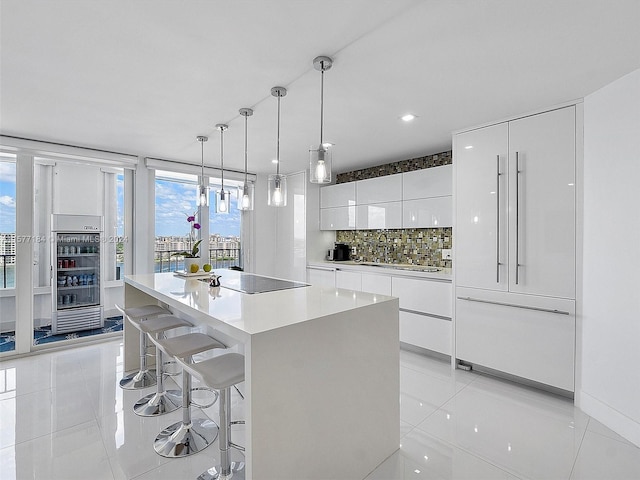 kitchen featuring pendant lighting, white cabinetry, backsplash, a center island, and light tile patterned flooring