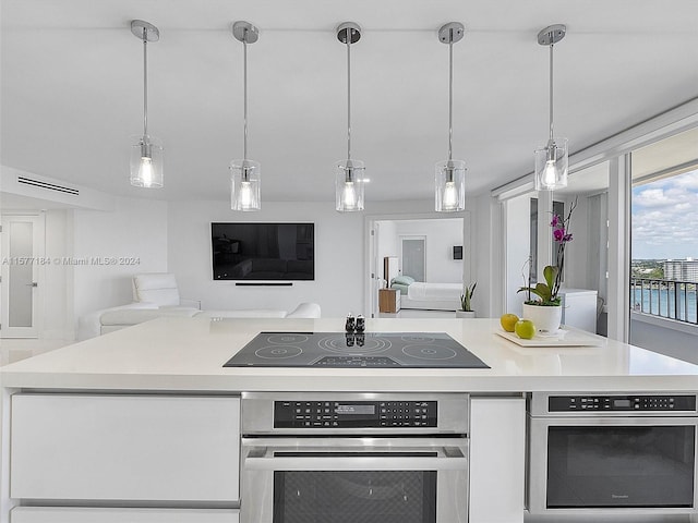 kitchen featuring black electric stovetop, oven, and white cabinetry