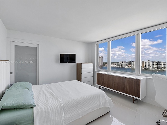 bedroom with radiator and light tile patterned flooring