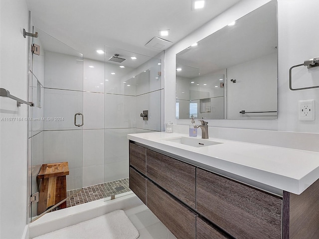 bathroom featuring vanity, a shower with shower door, and tile patterned floors