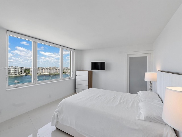 tiled bedroom featuring a water view