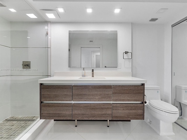 bathroom featuring vanity, toilet, walk in shower, and tile patterned floors