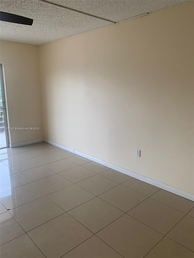 spare room with a textured ceiling and tile floors