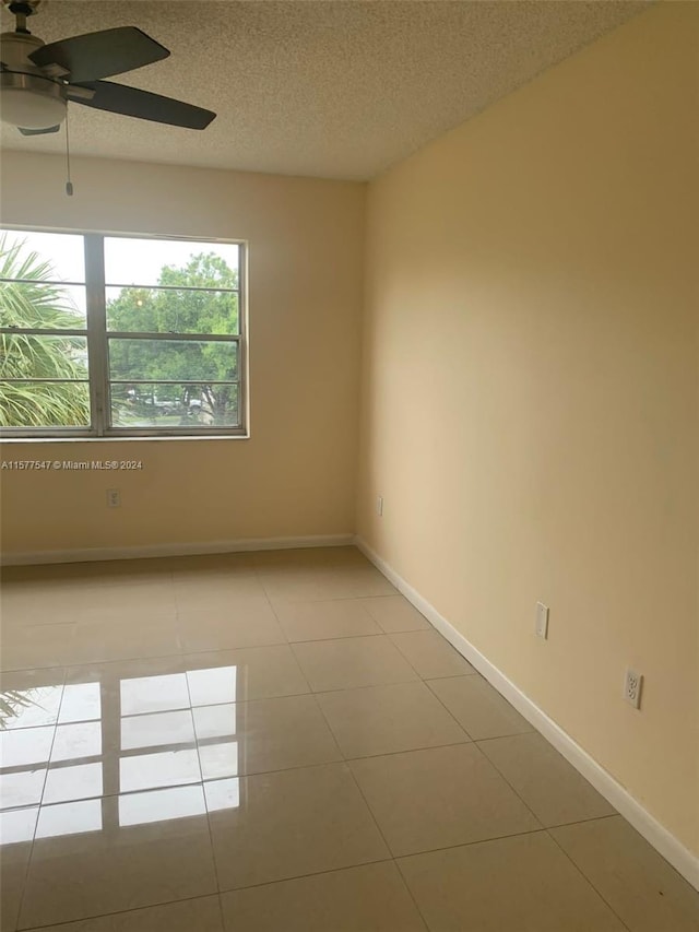 tiled spare room featuring ceiling fan and a textured ceiling