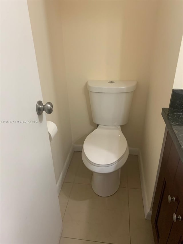 bathroom with vanity, tile floors, and toilet