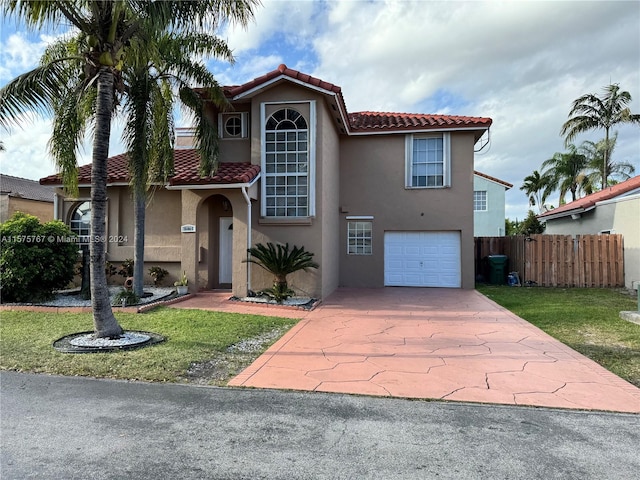 mediterranean / spanish-style house featuring a garage and a front yard