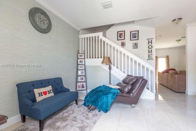 sitting room with ornamental molding and tile patterned floors