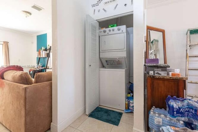 washroom featuring stacked washer / dryer and light tile patterned floors