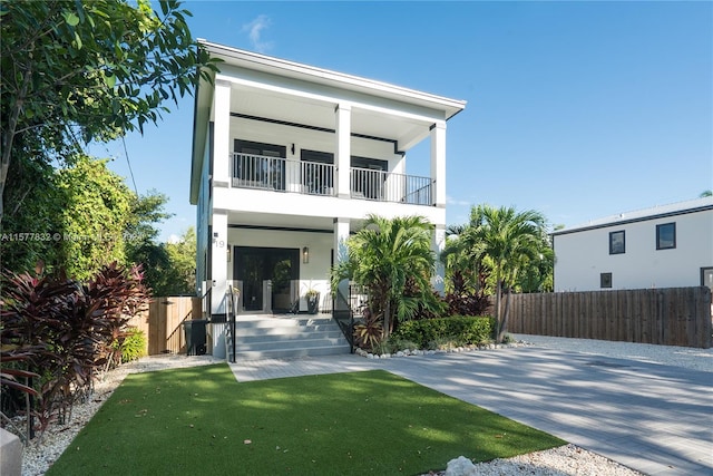 exterior space with a front lawn and a balcony