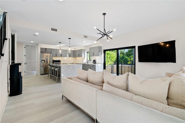 living room featuring light wood-type flooring and a chandelier