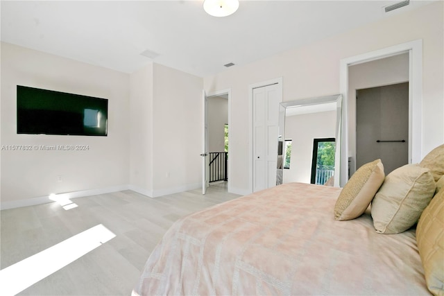 bedroom featuring light wood-type flooring and access to outside