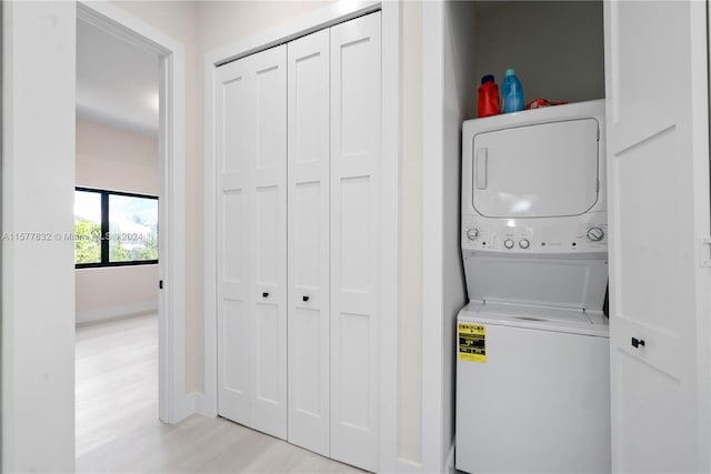 laundry area featuring light hardwood / wood-style flooring and stacked washing maching and dryer