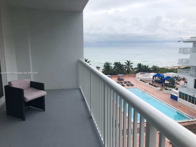 balcony featuring a water view and a community pool