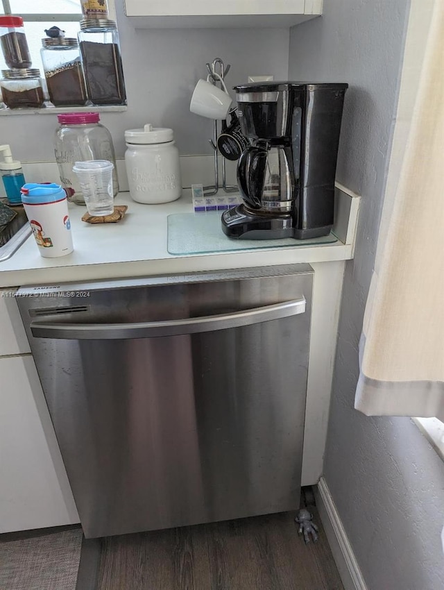 room details featuring stainless steel dishwasher and dark hardwood / wood-style floors