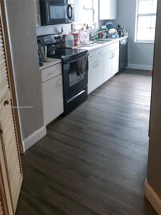 kitchen featuring white cabinetry, dark hardwood / wood-style flooring, black appliances, and sink