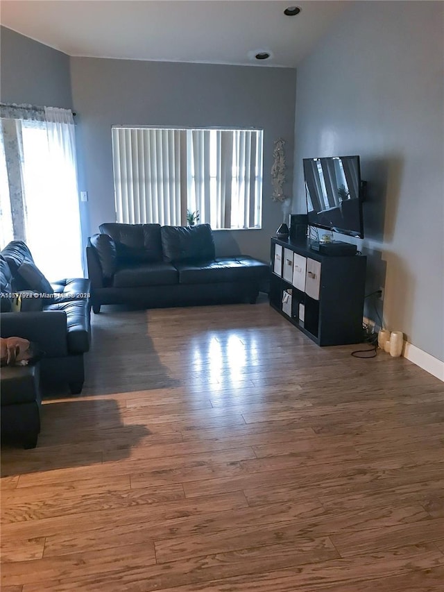 living room with dark wood-type flooring and vaulted ceiling