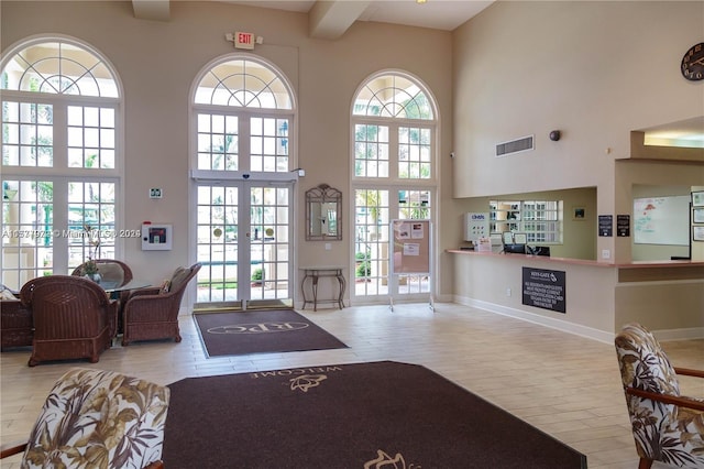 entrance foyer featuring plenty of natural light, french doors, and a high ceiling