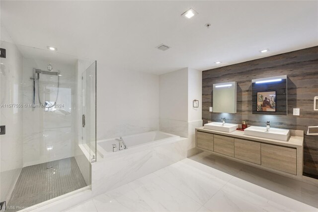 bathroom featuring wooden walls, dual bowl vanity, shower with separate bathtub, and tile flooring