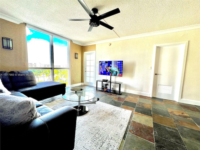 living room with ornamental molding, ceiling fan, dark tile flooring, and a textured ceiling