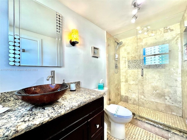 bathroom with walk in shower, toilet, tile floors, and vanity