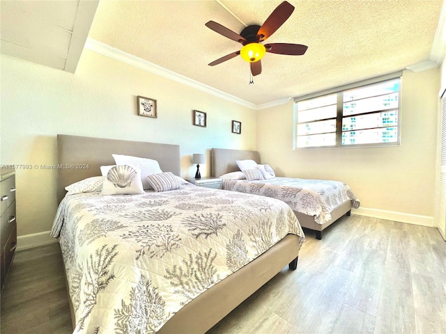 bedroom with wood-type flooring, ceiling fan, crown molding, and a textured ceiling