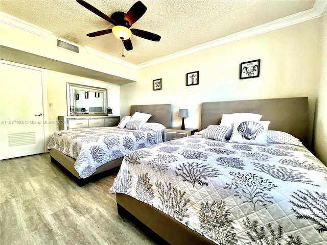 bedroom with a textured ceiling, ceiling fan, crown molding, and hardwood / wood-style flooring