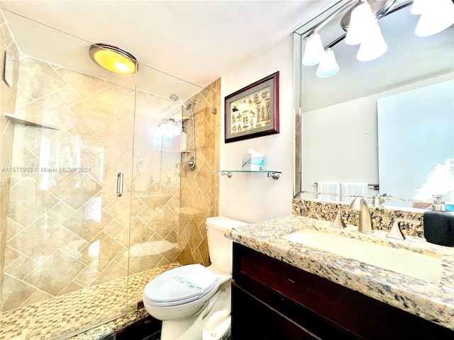 bathroom with walk in shower, vanity, and toilet