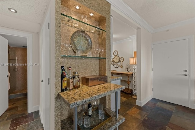 bar with stone countertops, a textured ceiling, dark tile flooring, and crown molding