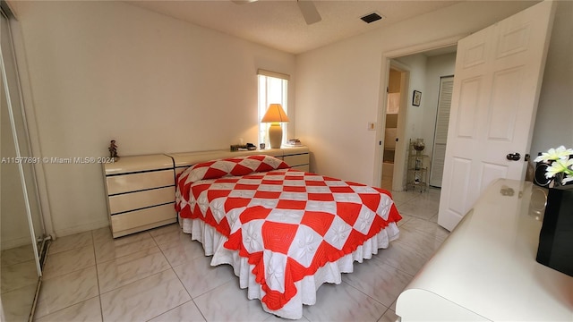 tiled bedroom with a closet and ceiling fan