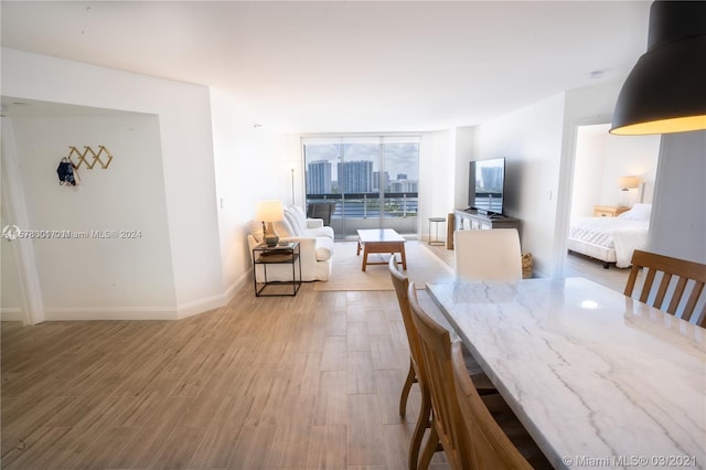 dining space featuring floor to ceiling windows and hardwood / wood-style flooring