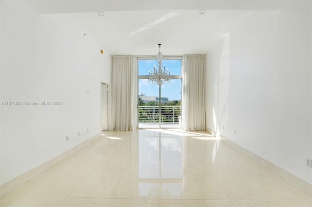 tiled empty room featuring a chandelier