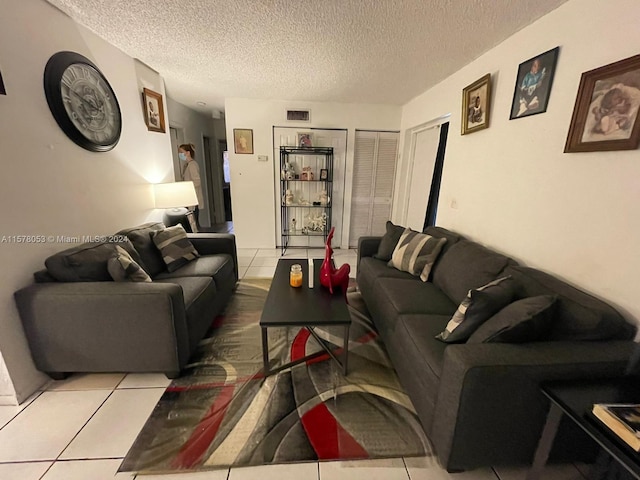 tiled living room featuring a textured ceiling