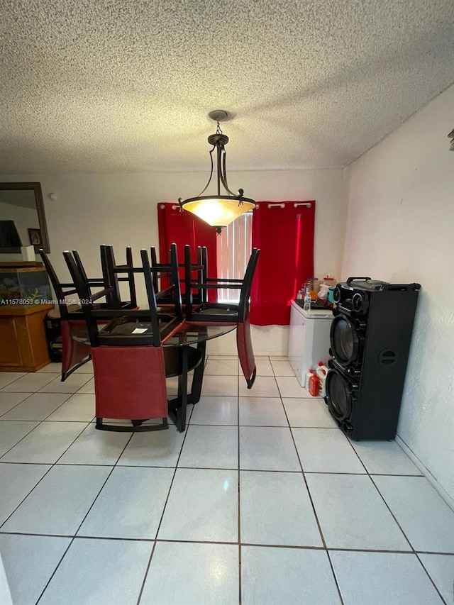 dining area featuring tile flooring and a textured ceiling