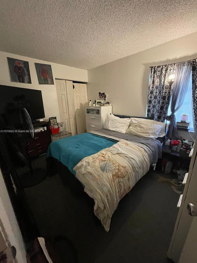 bedroom with a closet, carpet, and a textured ceiling