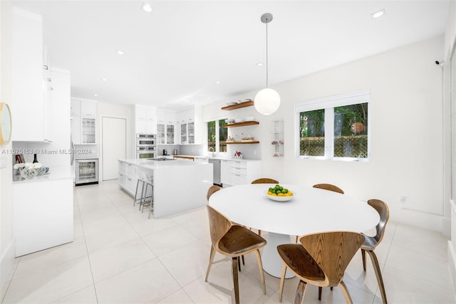 dining room featuring sink, light tile floors, and beverage cooler