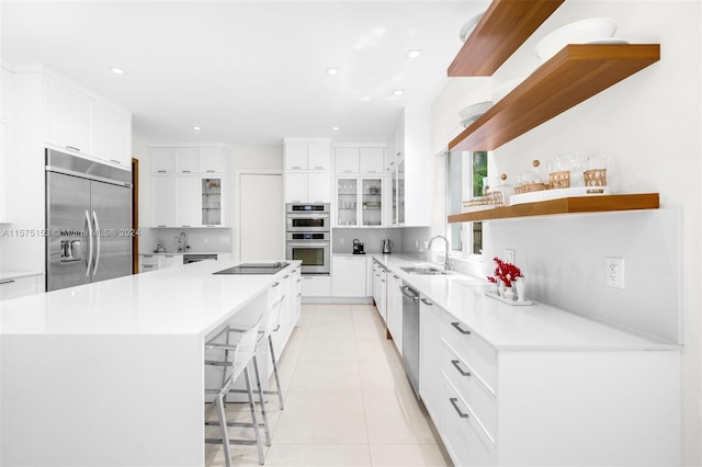 kitchen featuring sink, white cabinetry, stainless steel appliances, and a spacious island