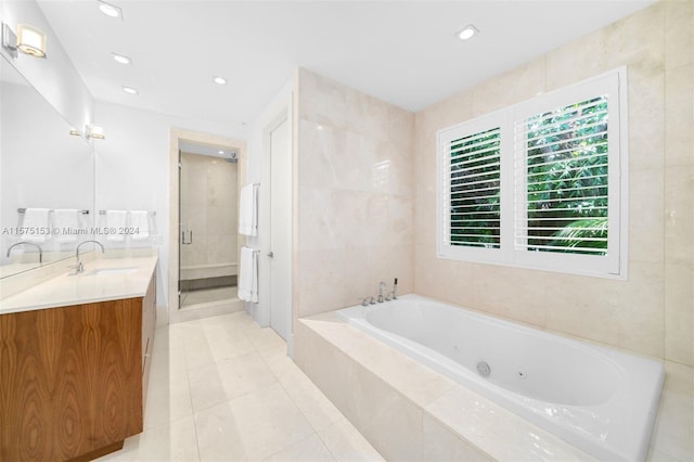 bathroom with tile walls, vanity, tile floors, and tiled tub