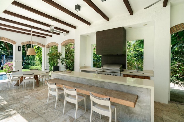 view of patio / terrace featuring ceiling fan, a grill, a wet bar, and area for grilling