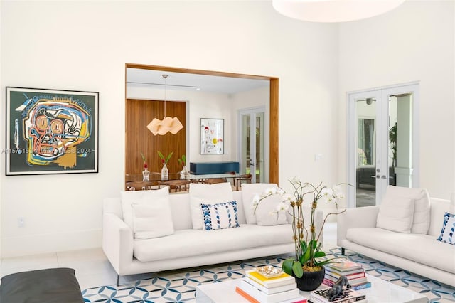 living room with tile flooring, french doors, and a towering ceiling