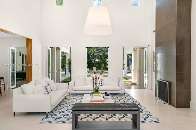 living room featuring light tile flooring and a high ceiling