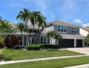 view of front of property featuring a front lawn and a garage