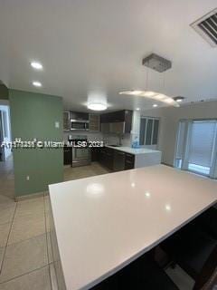 kitchen with kitchen peninsula and light tile flooring