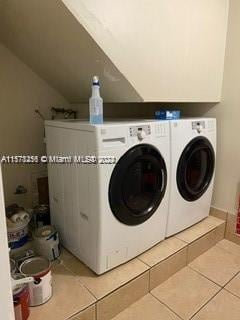 laundry room featuring independent washer and dryer and light tile floors