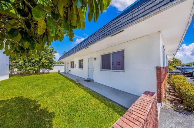 view of side of home with a yard