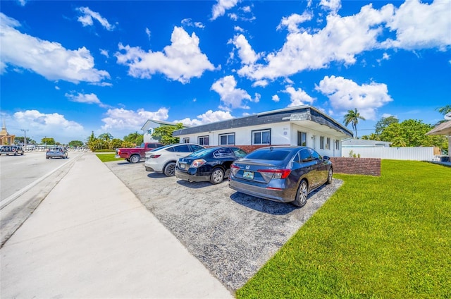 view of parking / parking lot with a lawn