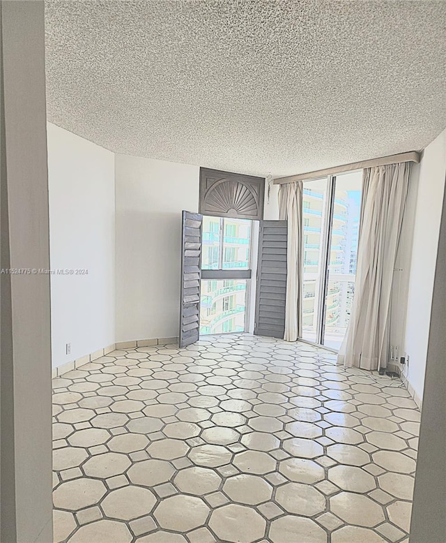 spare room with tile flooring and a textured ceiling