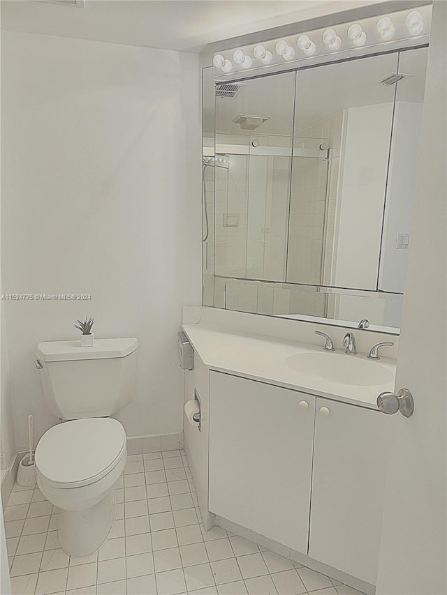 bathroom featuring vanity with extensive cabinet space, toilet, and tile flooring