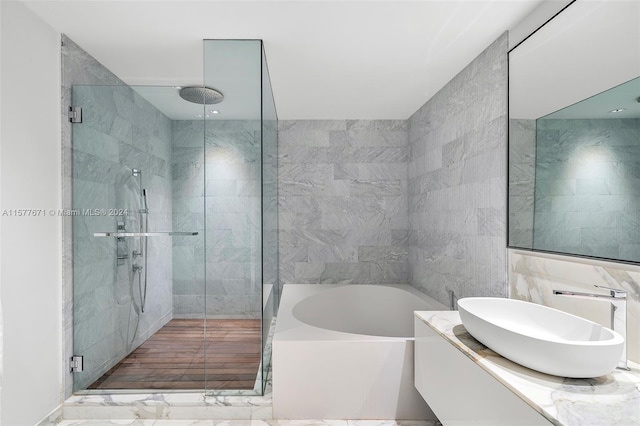 bathroom featuring vanity, tile flooring, tile walls, and plus walk in shower